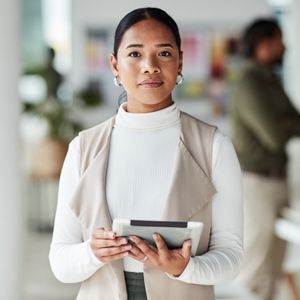Woman holding a tablet in an office setting.